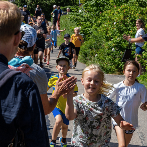 Niños corriendo y chocando los cinco con los espectadores 