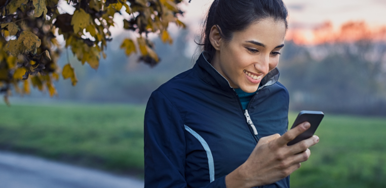 Mujer deportista leyendo el correo electrónico en su teléfono